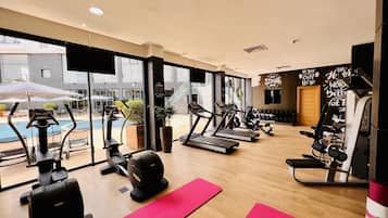 A gym with treadmills, weights, and exercise mats.