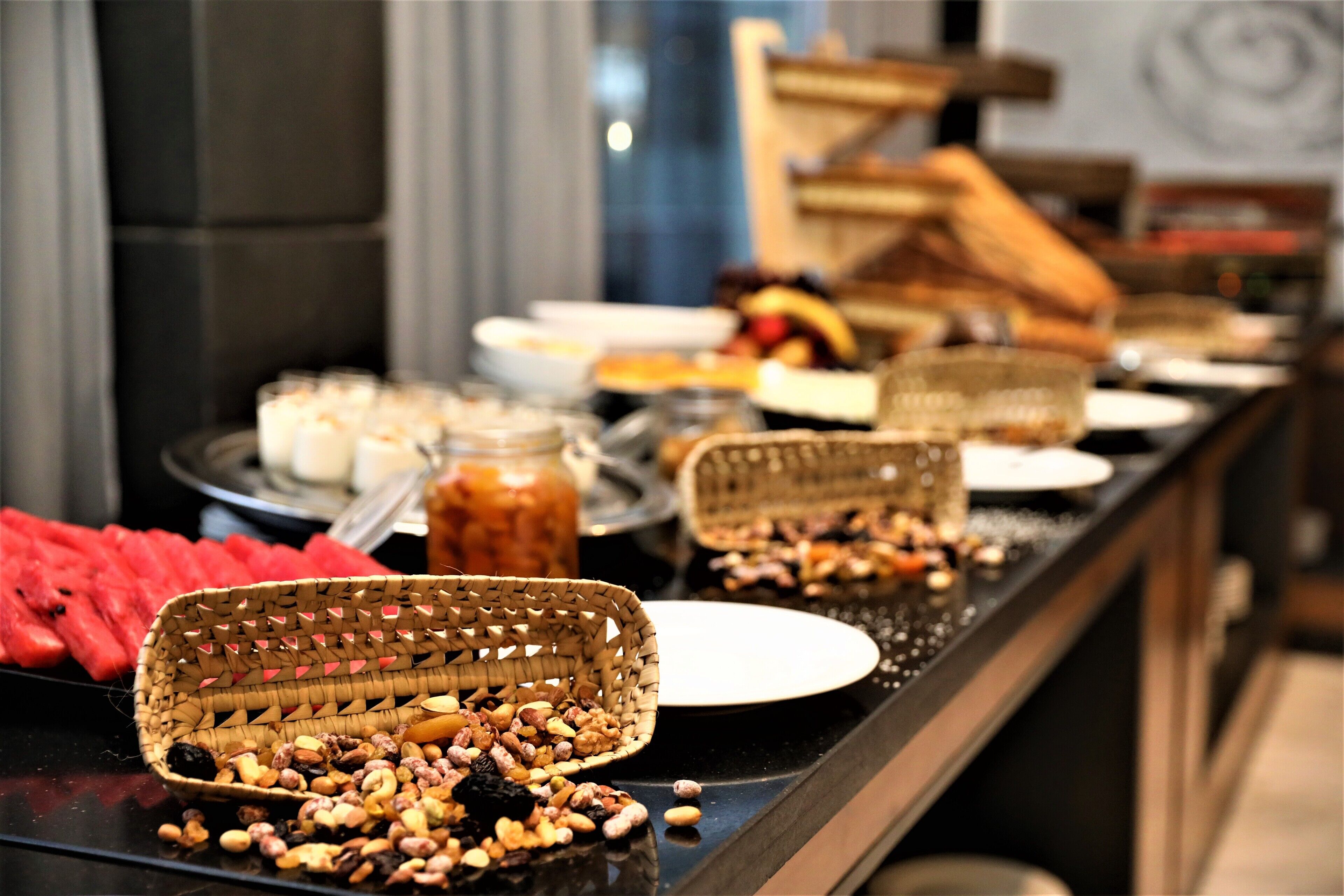 Un buffet proposant une variété d’aliments, notamment des fruits, des noix et des pâtisseries.