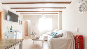 Ein Wohnzimmer mit einer Couch, einem Fernseher, einem Tisch und einer roten Telefonzelle.