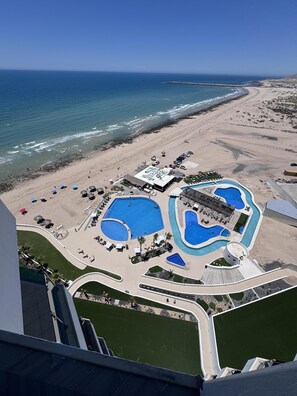 Ein Resort mit mehreren Pools, einem Strand und Blick auf den Ozean.