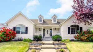 A two-story house with a front porch, a central door, and a symmetrical window arrangement.