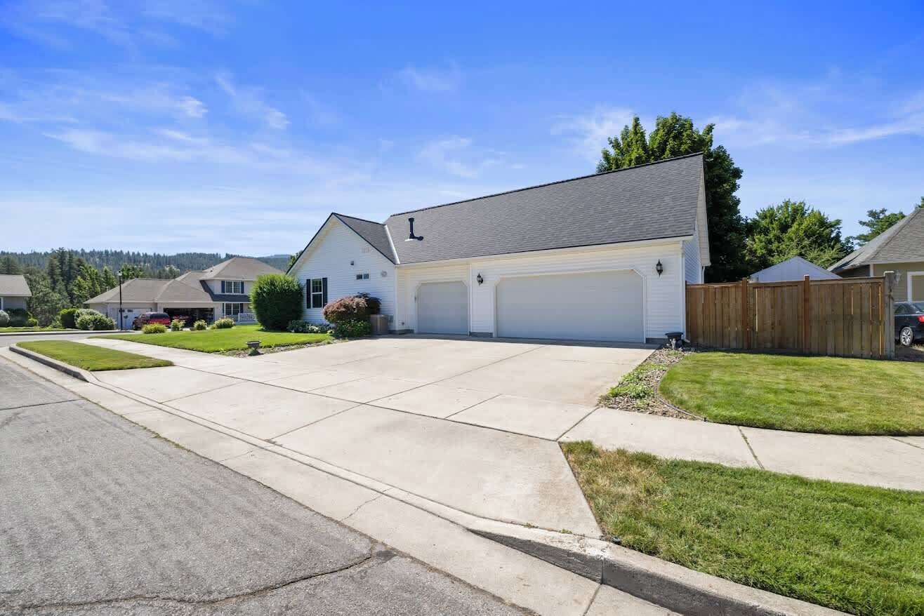 A residential house with a garage, driveway, and well-maintained lawn.