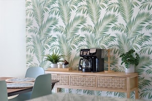Enjoy a casual dining experience in this inviting space, featuring a coffee maker and a potted plant.