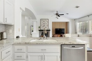 Enjoy cooking in the well-equipped kitchen with a granite countertop, integrated sink, and stainless steel appliances.