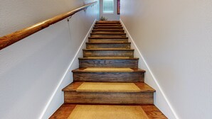 Una escalera de madera con peldaños alfombrados y barandilla de madera.
