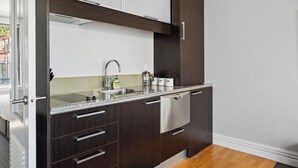 Une cuisine moderne avec des meubles de couleur bois foncé, un évier en acier inoxydable et un lave-vaisselle encastré.