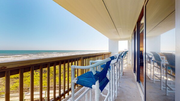 Un balcon avec vue sur la plage et l’océan.