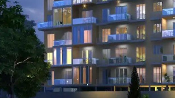 A multi-story hotel with balconies on each floor, large windows, and a modern architectural design.
