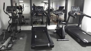A gym with treadmills, elliptical machines, and a stationary bike.