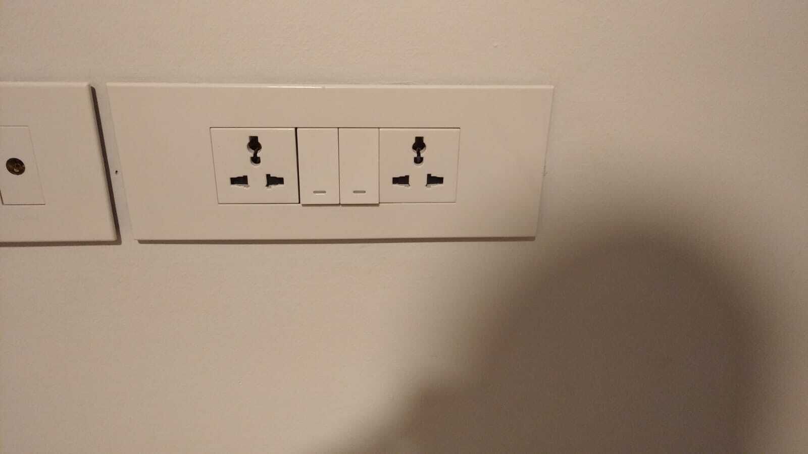 Un mur muni de deux prises électriques, dont une avec une seule fiche et l’autre avec deux fiches.