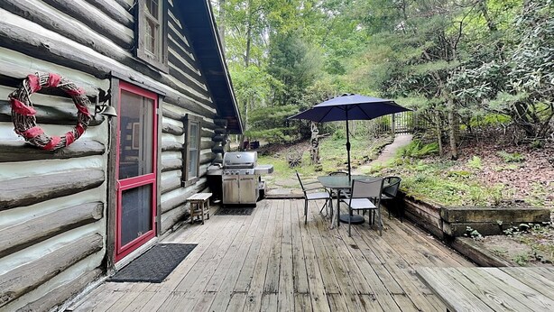 A log cabin with a deck, a grill, and outdoor seating. - Tucked Inn by Taylor Made Deep Creek (Swanton)