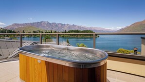 A hot tub on a balcony overlooking a lake with mountains in the background. - SPACIOUS UNIT WITH VIEWS AND BALCONY (Queenstown)