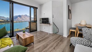 A modern living room with a large sliding glass door leading to a balcony with a lake view. - A LUCKIE CHARM - 3-BEDROOM TOWNHOUSE WITH SPECTACULAR VIEW (Queenstown Hill)