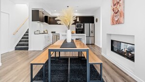 A modern kitchen with white cabinets, a central island, and a microwave.