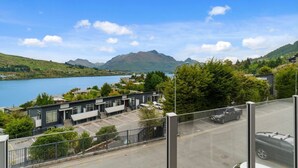 A modern building with a parking lot and a view of a lake and mountains. - 2-BEDROOM APARTMENT - BEECHWOOD (Queenstown)