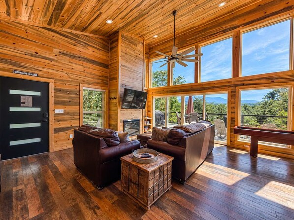 A spacious living area with a fireplace, leather sofas, and a wooden coffee table.