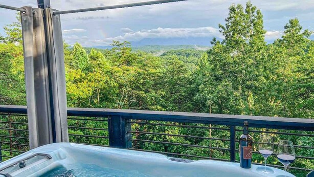 Ein Whirlpool auf einem Balkon mit Blick auf einen Wald.