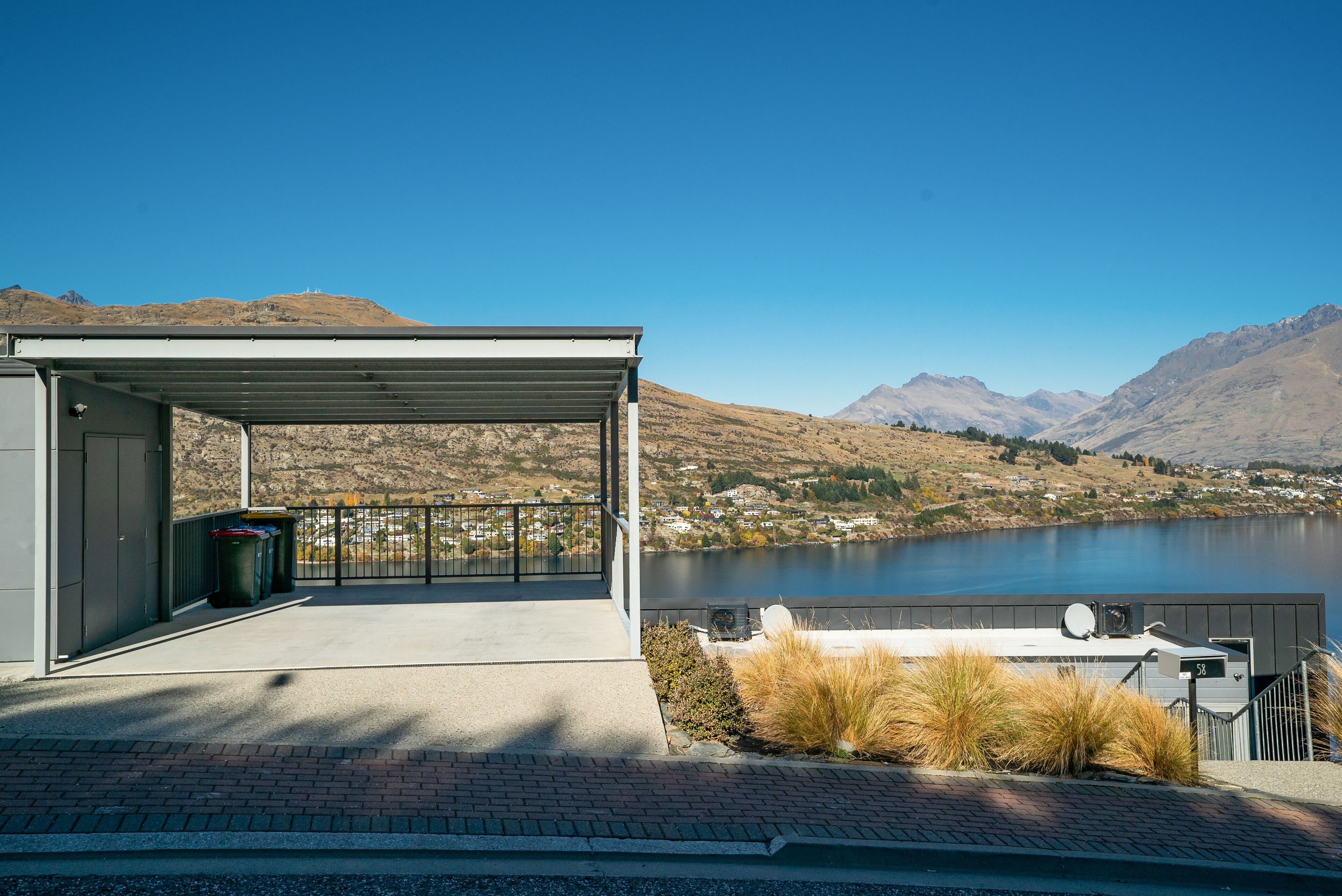A covered outdoor area with a view of a lake and mountains.