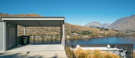 A covered outdoor area with a view of a lake and mountains.