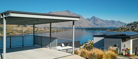 A covered outdoor area with a view of a lake and mountains.
