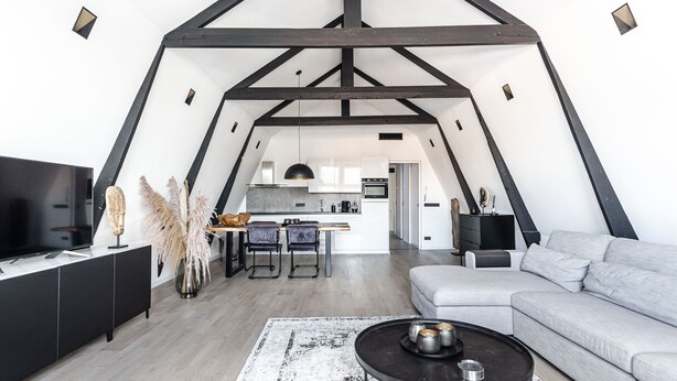 A modern loft with a kitchen, dining area, and living space.