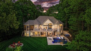 A large, two-story house with a covered patio, a swimming pool, and a well-maintained lawn. - Sunset on Ballycastle w/Heated Pool & Optional Boat Rental (Mooresville)