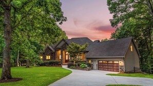 A two-story house with a stone facade, a driveway, and a well-maintained lawn. - Sunset on Ballycastle w/Heated Pool & Optional Boat Rental (Mooresville)