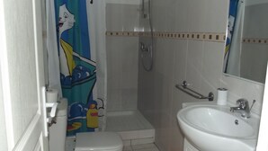 Un baño con ducha, inodoro y lavamanos.