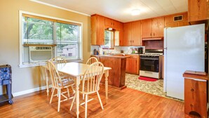 A kitchen with wooden cabinets, a dining table with chairs, a refrigerator, and an oven. - Welcoming Biggers Home - Great Duck Hunting! (Biggers)
