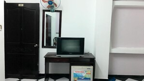 A room with a closed door labeled 401, a standing fan, a television on a wooden stand, and a Toshiba box on the floor. - Hoang Nam Hotel by Zuzu (Ho Chi Minh Municipality)