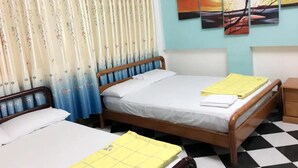A room with two beds, a checkered floor, and a painting on the wall. - Hoang Nam Hotel by Zuzu (Ho Chi Minh Municipality)