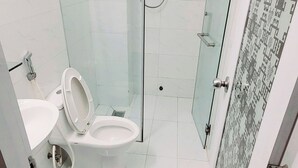 A modern bathroom with a glass-enclosed shower, a white toilet, and a sink. - Hoang Nam Hotel by Zuzu (Ho Chi Minh Municipality)
