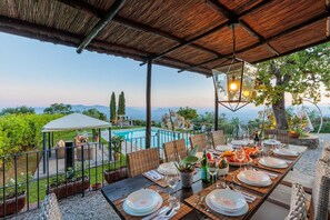 An outdoor dining area with a view of a pool and mountains. - Tuscan Fizz Villa a Vineyards Retreat (Capannori)