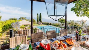 An outdoor dining area with a pool, wicker furniture, and a clear view of the mountains. - Tuscan Fizz Villa a Vineyards Retreat (Capannori)