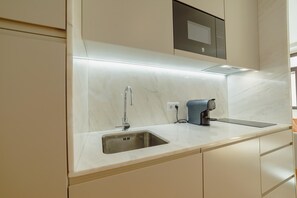 A modern kitchen with a built-in sink, a coffee maker, and a microwave. - Legacy Oporto Design Apartment D by Vacationy (Porto)