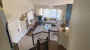 A spacious living area with a sofa, coffee table, and a dining table.
