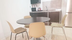 A modern kitchen with a round dining table and four chairs. - Picasso neighborhood. Beautiful flat in central 2B (Málaga)