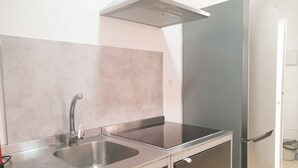 A kitchen with a stainless steel sink, a modern range hood, and a built-in refrigerator. - Picasso neighborhood. Beautiful flat in central 2B (Málaga)
