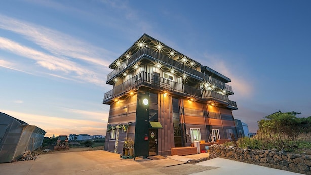A multi-story building with balconies and outdoor lighting. - Jeju Hoyeongfarm Stay (Jeju City)