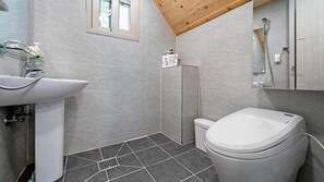 Een badkamer met een witte wastafel, toilet en douche.