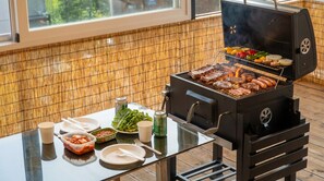 Eine moderne Küche mit integriertem Grill, einem Esstisch mit Tellern, Besteck und Gewürzen.