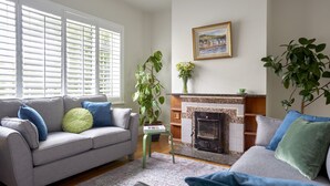 A living room with a fireplace, a sofa, and a coffee table. - Kirrary Townhouse 4 bedroom house VRBO (Dingle)