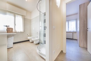 Une salle de bain moderne avec une douche à l’italienne, un lavabo et des toilettes.