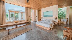 A spacious bedroom with a large bed, a ceiling fan, and a view of the outdoors. - Villa Boya (Canggu)