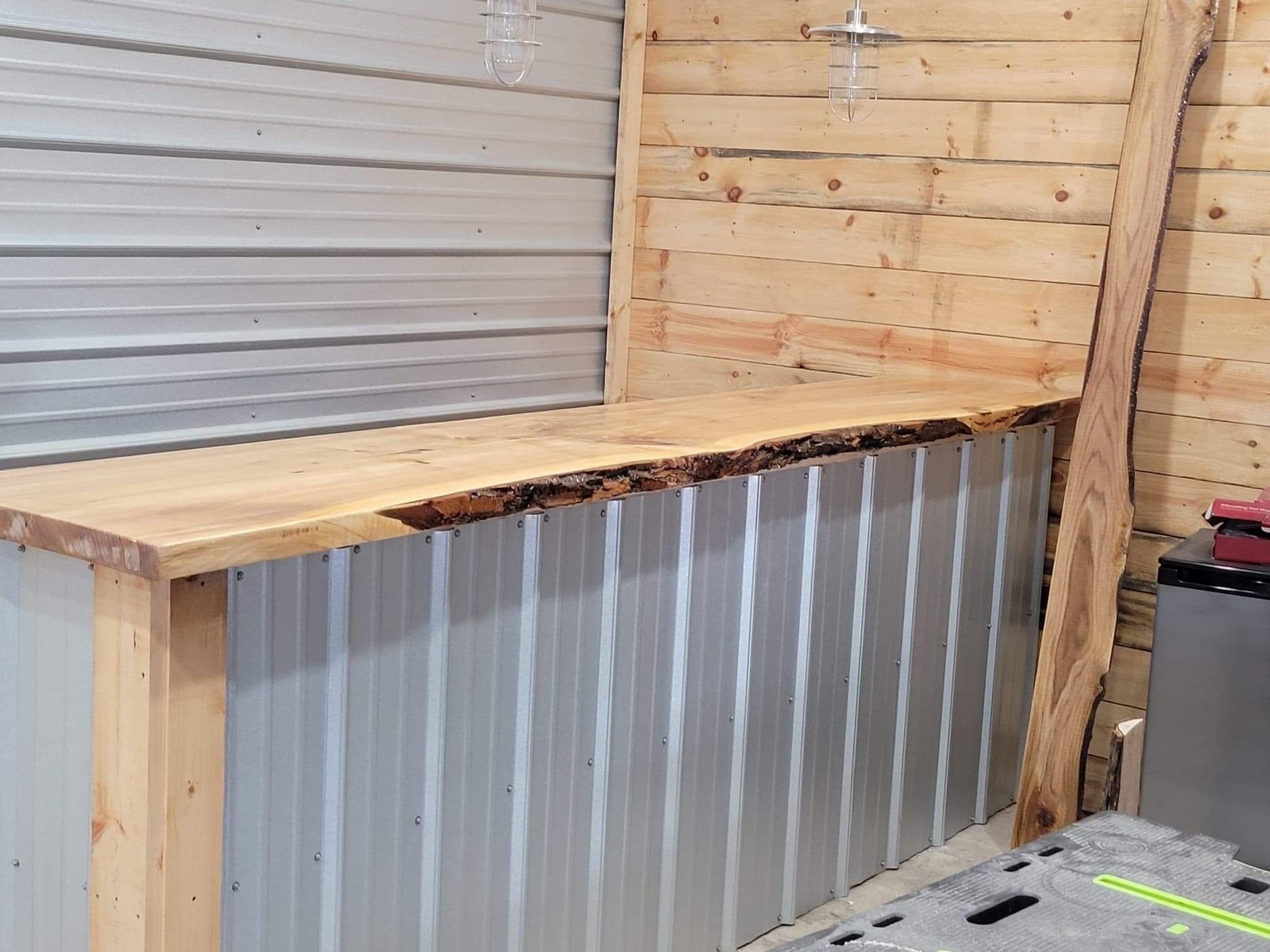 A corner of a room with a wooden counter, metal siding, and a small appliance.