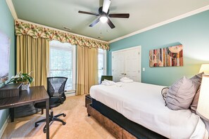 A bedroom with a bed, a desk, a chair, a ceiling fan, and a window with curtains. - Lake Norman Cove Home w/ Golf Sim & Kayaks (Sherrills Ford)
