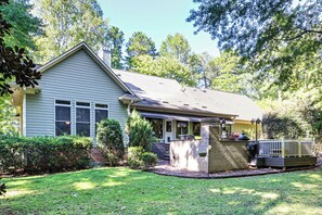 A single-story house with a front porch, a brick chimney, and a small deck. - Lake Norman Cove Home w/ Golf Sim & Kayaks (Sherrills Ford)