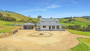 A two-story house with a covered patio and a circular fire pit in the front yard. - Manandel - Rural Retreat (Bonnie Doon)