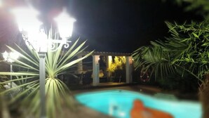 A nighttime pool area with a light fixture and palm trees. - Gd T2 5 min from Calanques and Carry (Ensuès-la-Redonne)