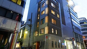 Un immeuble moderne de grande hauteur, doté de nombreux étages, de grandes fenêtres et d’une entrée imposante.